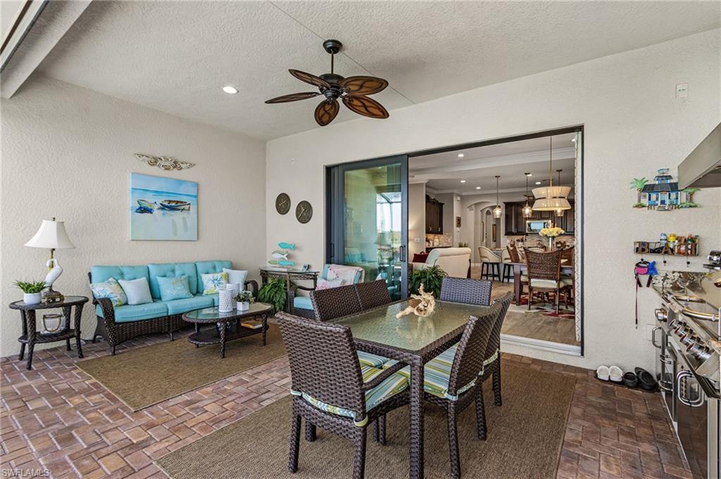 1434 Redona Way Naples, FL 34113 - Photo 31 of 47 a dining room with furniture a rug and a chandelier