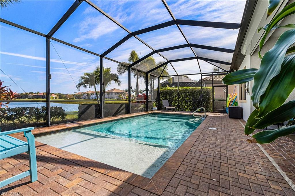 1434 Redona Way Naples, FL 34113 - Photo 32 of 47 a view of a patio with a table and chairs under an umbrella