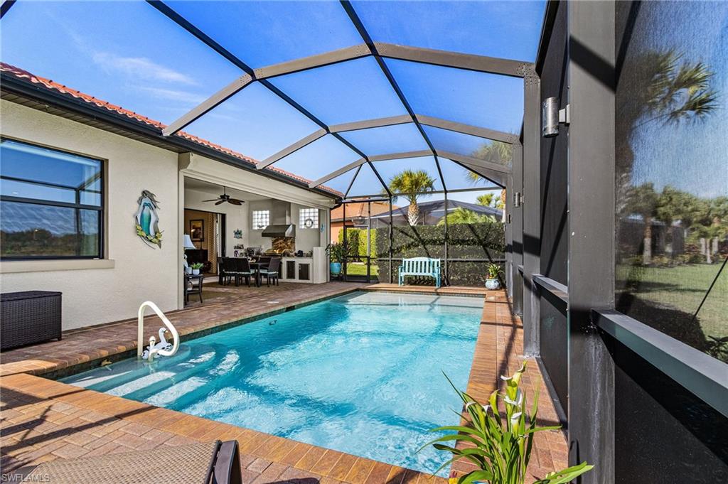 1434 Redona Way Naples, FL 34113 - Photo 33 of 47 a view of a patio with table and chairs under an umbrella
