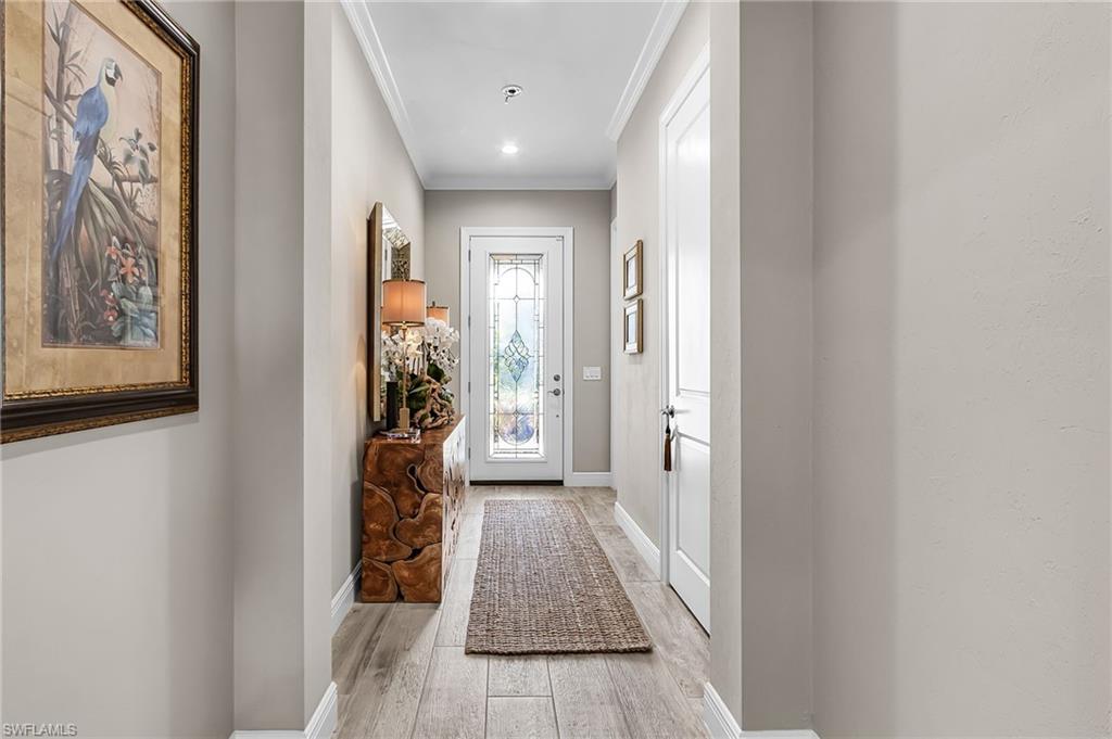 1434 Redona Way Naples, FL 34113 - Photo 4 of 47 a view of a hallway with wooden floor and stairs