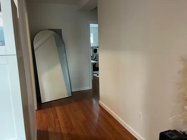 a view of a hallway with wooden floor