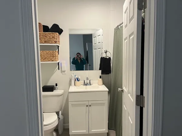 a bathroom with a toilet sink and mirror
