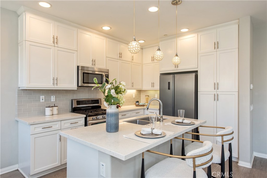 68 Origin Irvine, CA 92618 - Photo 16 of 43 a kitchen with stainless steel appliances kitchen island granite countertop a kitchen island a stove a table and chairs