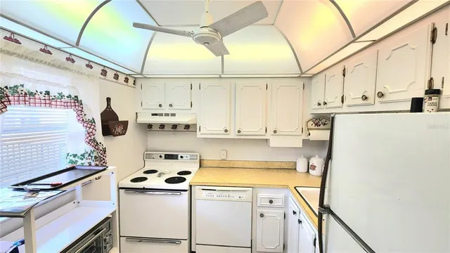 a kitchen with a refrigerator a stove and a cabinets