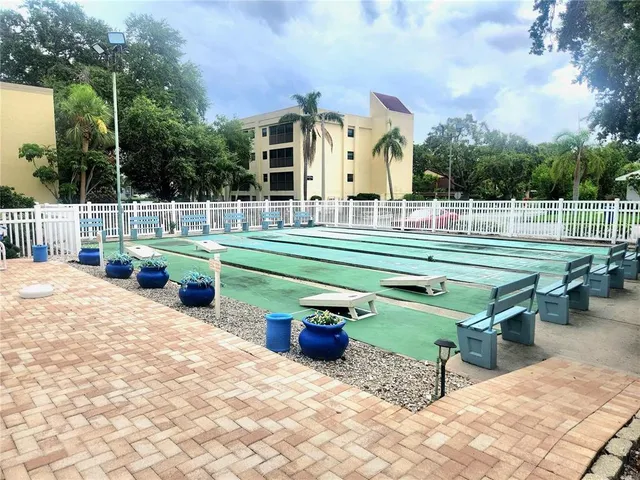 a view of a swimming pool with lawn chairs and plants