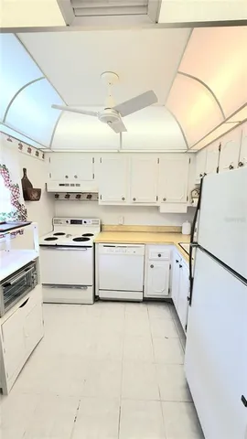 a kitchen with a stove a refrigerator and white cabinets