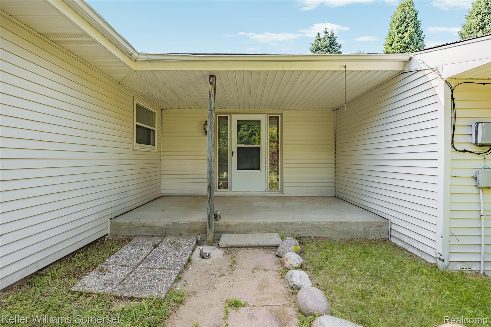 2344 Rochester Road Leonard, MI 48367 - Photo 6 of 66 Covered entryway featuring a concrete patio, white siding, and a partial light fixture
