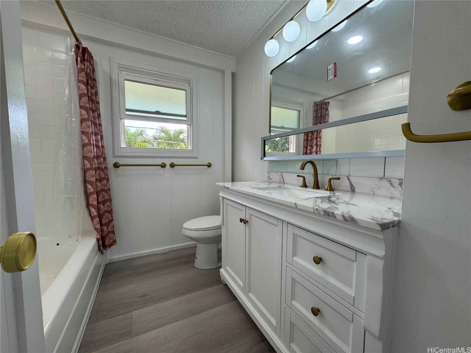 2326 Rose Street Honolulu, HI 96819 - Photo 12 of 19 a bathroom with a granite countertop sink toilet and mirror