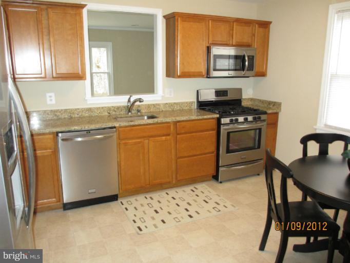 2801 Sheraton Street Silver Spring, MD 20906 - Photo 12 of 15 a kitchen with stainless steel appliances kitchen island granite countertop a sink and cabinets