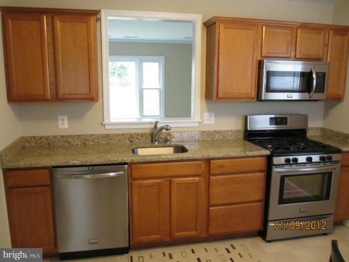 2801 Sheraton Street Silver Spring, MD 20906 - Photo 10 of 15 a kitchen with stainless steel appliances granite countertop a sink stove and microwave