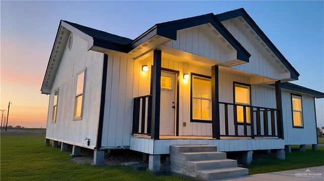 a view of house with yard and stairs