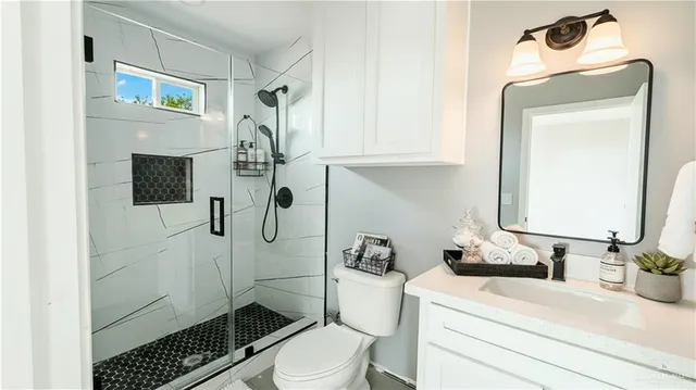 a bathroom with a sink a toilet and shower