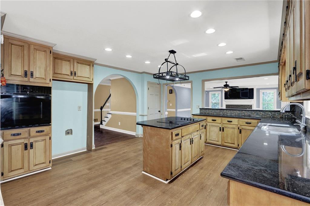 5010 Oak Tree Lane Stone Mountain, GA 30087 - Photo 12 of 35 a large kitchen with stainless steel appliances granite countertop a sink a stove and a wooden floors