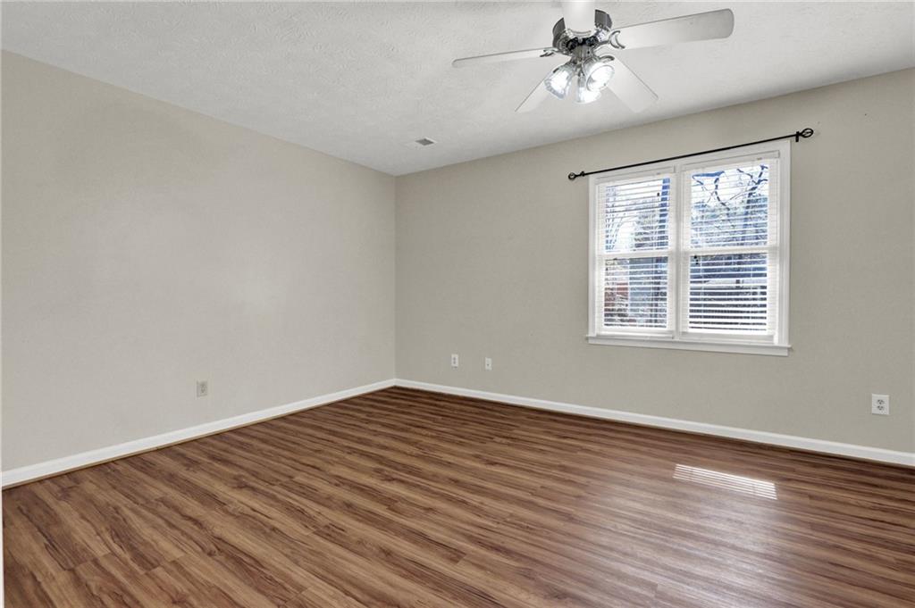 5010 Oak Tree Lane Stone Mountain, GA 30087 - Photo 18 of 35 a view of an empty room with wooden floor and a window