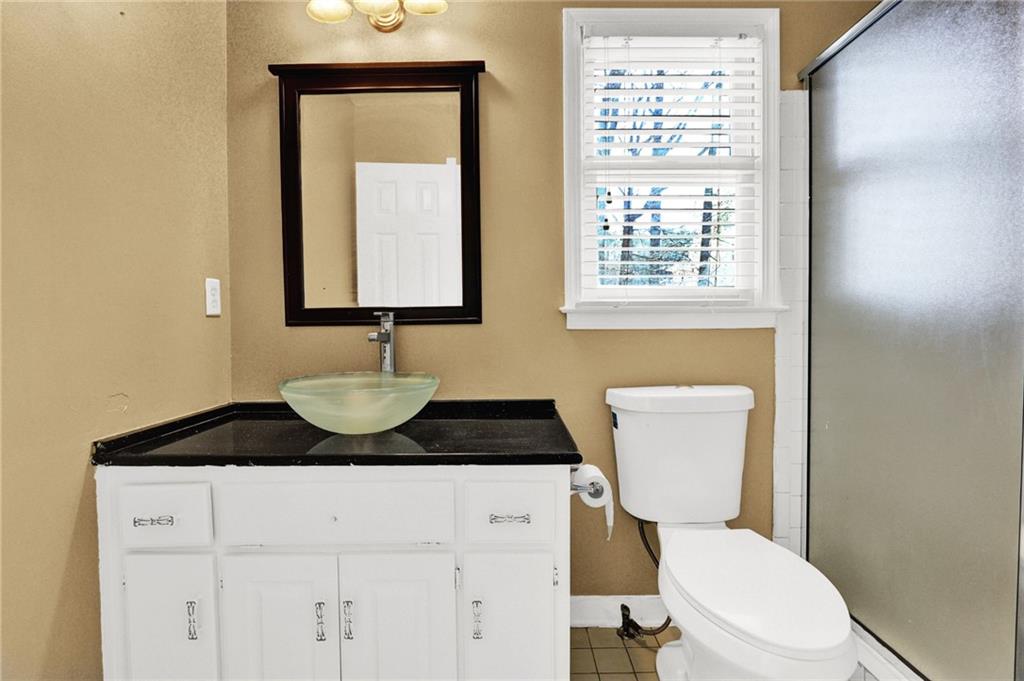 5010 Oak Tree Lane Stone Mountain, GA 30087 - Photo 21 of 35 a bathroom with a toilet a sink and a window