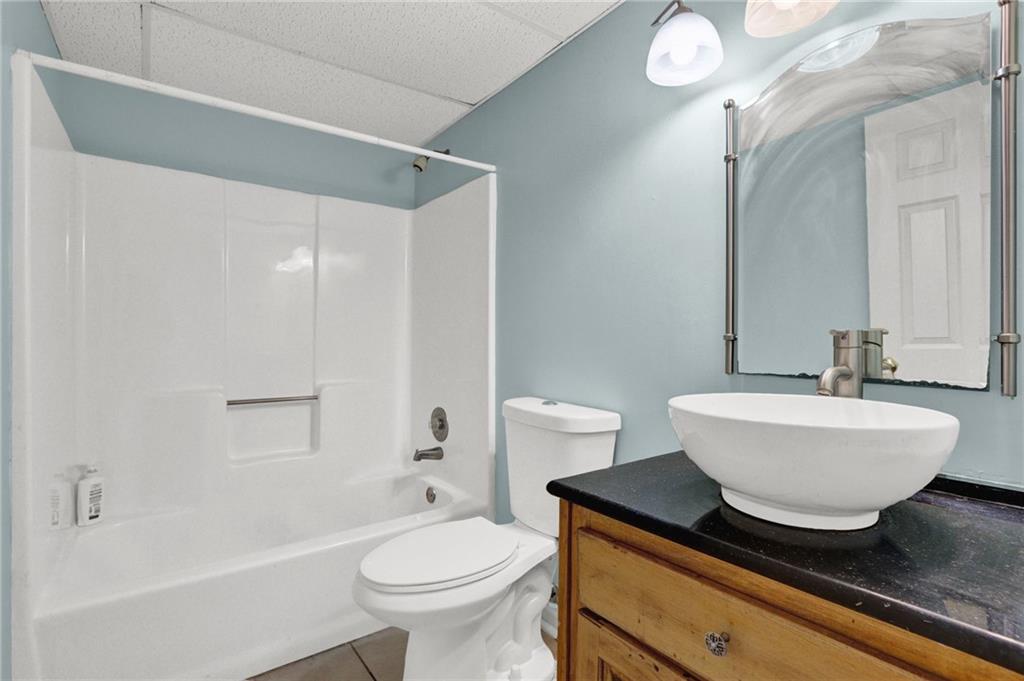 5010 Oak Tree Lane Stone Mountain, GA 30087 - Photo 31 of 35 a bathroom with a sink a toilet a mirror and bathtub