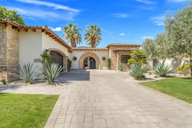 a dining room with furniture a large window and a chandelier