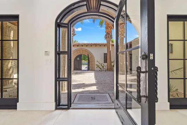 a spacious bedroom with a bed a couch and a large window