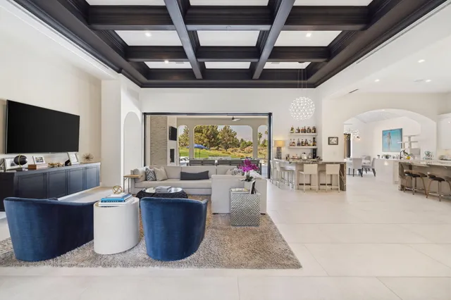 a living room with furniture a flat screen tv and a large window