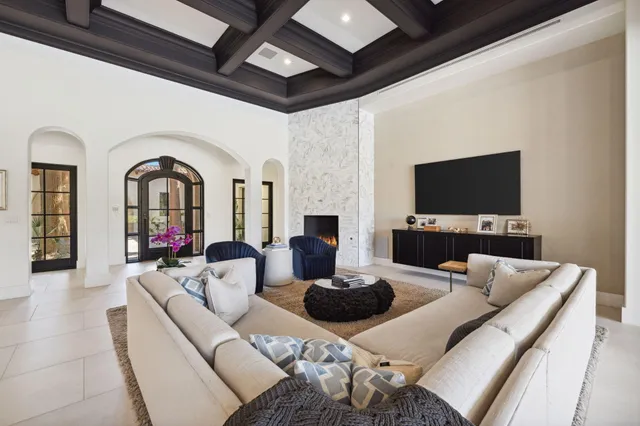 a living room with furniture a flat screen tv and a floor to ceiling window