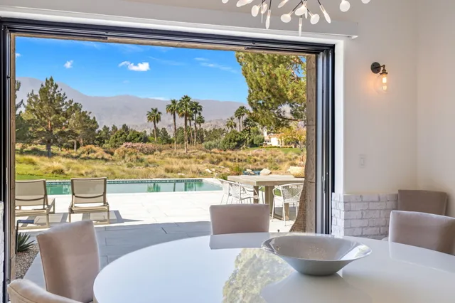 an aerial view of a house with a yard and a large tree