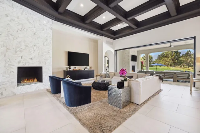 a living room with furniture a flat screen tv and a fireplace