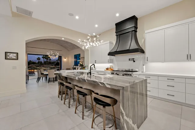 a kitchen with stainless steel appliances granite countertop a lot of counter space and wooden floors