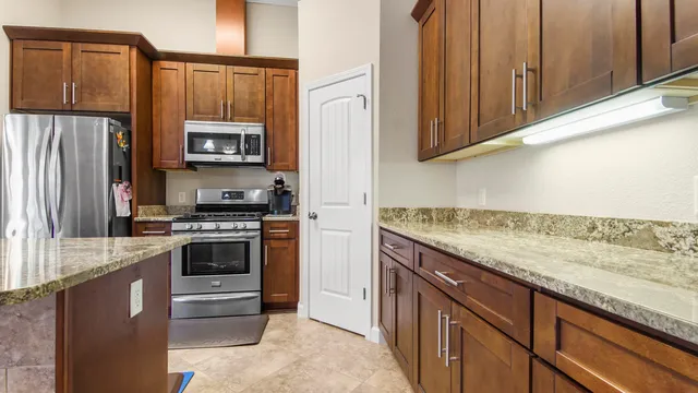 a kitchen with stainless steel appliances granite countertop a refrigerator stove and sink
