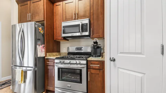 a kitchen with stainless steel appliances granite countertop a refrigerator stove and microwave