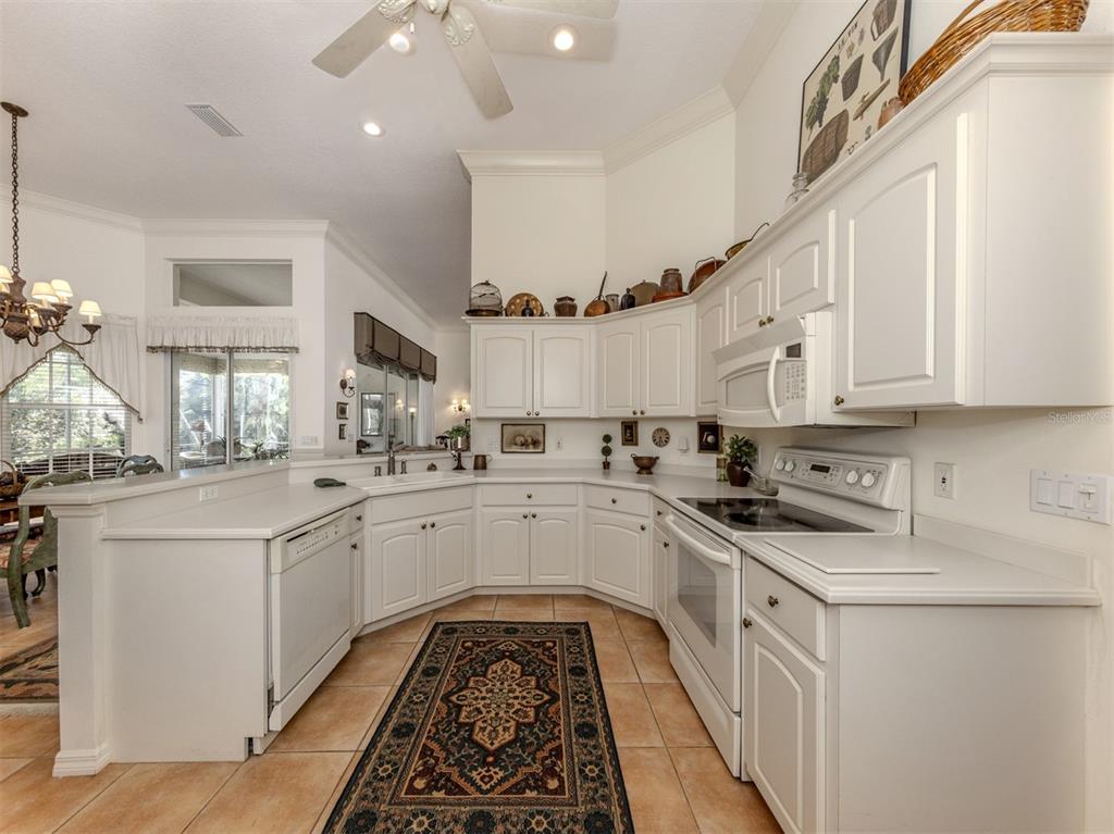 764 Sawgrass Bridge Road Venice, FL 34292 - Photo 10 of 60 a kitchen with white cabinets appliances and a sink