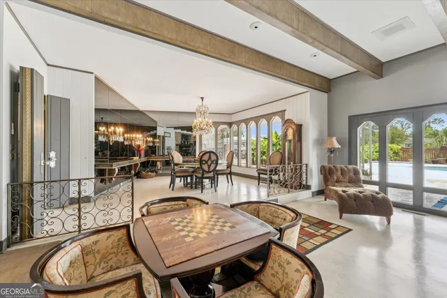 a view of a dining room with furniture a chandelier and wooden floor