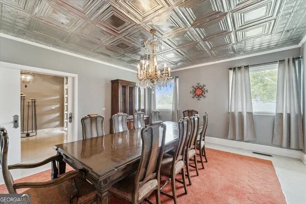 a dining room with stainless steel appliances a table chairs and a wooden floor