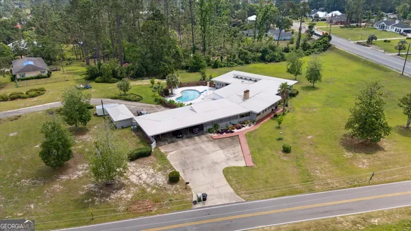 an aerial view of a house with yard swimming pool and outdoor seating