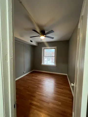 a view of empty room with wooden floor and fireplace
