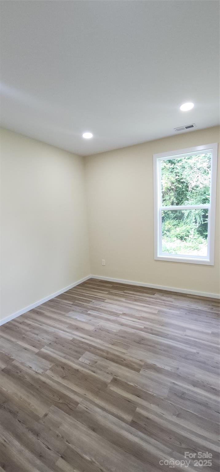 306 Ratchford Avenue Gastonia, NC 28054 - Photo 27 of 28 an empty room with wooden floor and windows