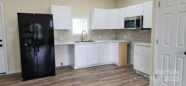 a kitchen with stainless steel appliances granite countertop a refrigerator and a stove top oven
