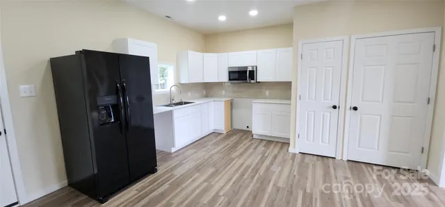 a kitchen with stainless steel appliances granite countertop a refrigerator and a sink