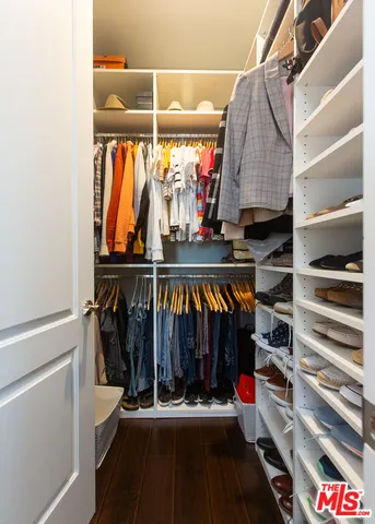 a view of walk in closet with clothes and shoes