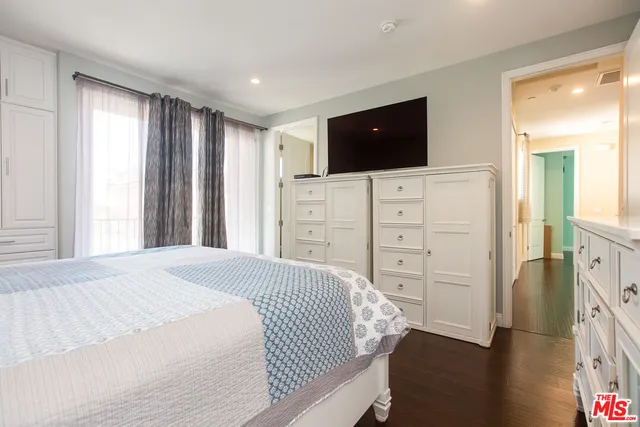 a spacious bedroom with a bed and a flat screen tv