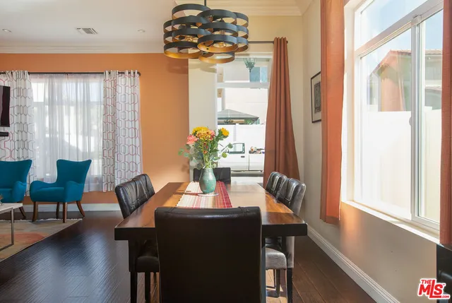 a dining room with furniture a chandelier and wooden floor