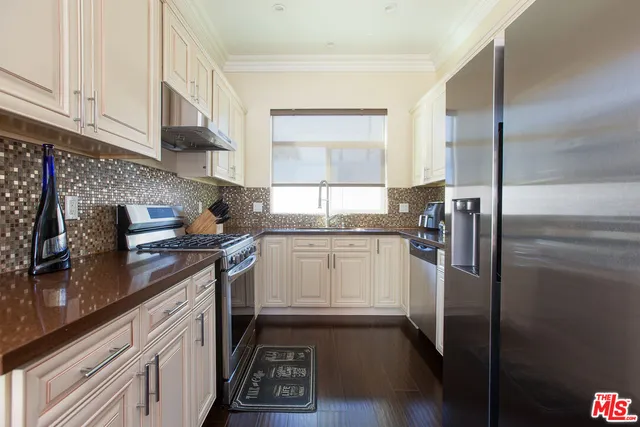 a kitchen with a refrigerator sink and cabinets