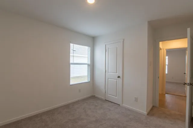 an empty room with windows and closet