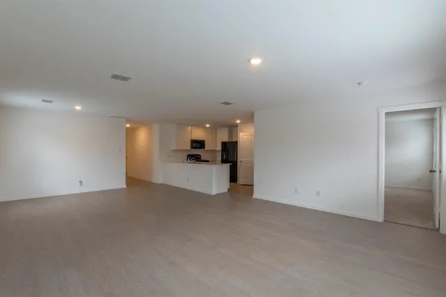 a view of empty room with kitchen