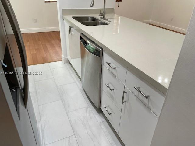 15325 Southwest 106th Terrace, Unit 618 Miami, FL 33196 - Photo 11 of 27 a kitchen with white cabinets a sink and dishwasher
