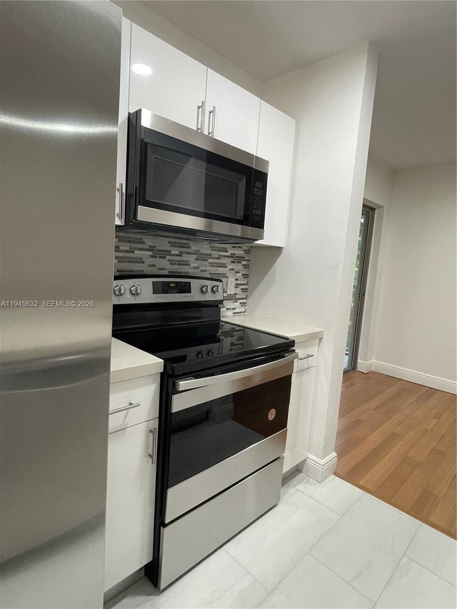15325 Southwest 106th Terrace, Unit 618 Miami, FL 33196 - Photo 13 of 27 a stove top oven sitting inside of a kitchen