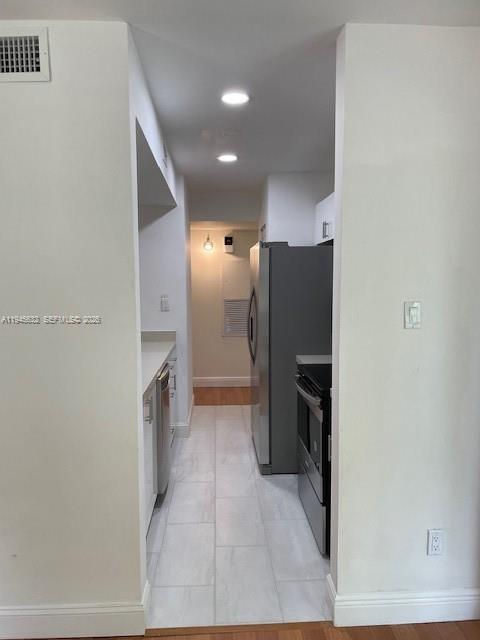 15325 Southwest 106th Terrace, Unit 618 Miami, FL 33196 - Photo 14 of 27 a view of a refrigerator in kitchen and an empty room