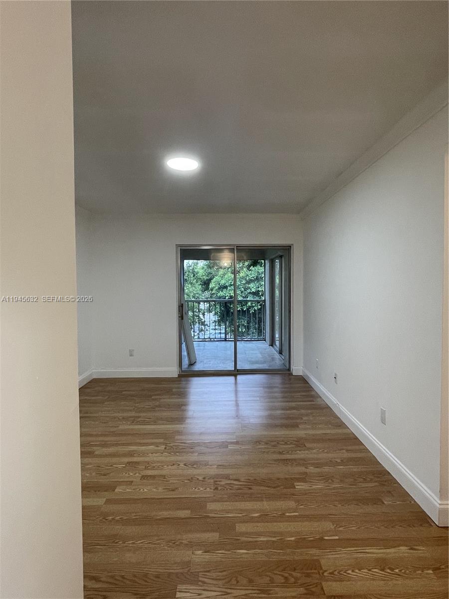 15325 Southwest 106th Terrace, Unit 618 Miami, FL 33196 - Photo 20 of 27 a view of an empty room with wooden floor and a window