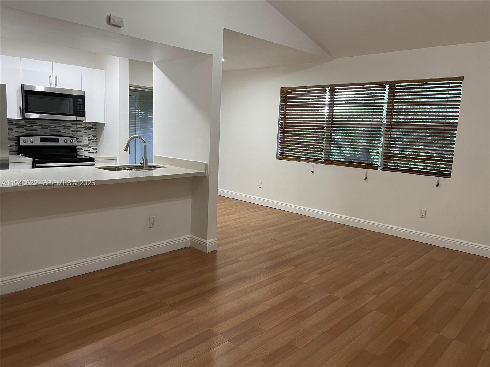 15325 Southwest 106th Terrace, Unit 618 Miami, FL 33196 - Photo 2 of 27 a view of kitchen with wooden floor and black white cabinet