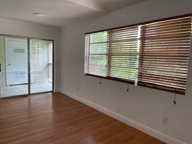 15325 Southwest 106th Terrace, Unit 618 Miami, FL 33196 - Photo 4 of 27 a view of an empty room with wooden floor and a window