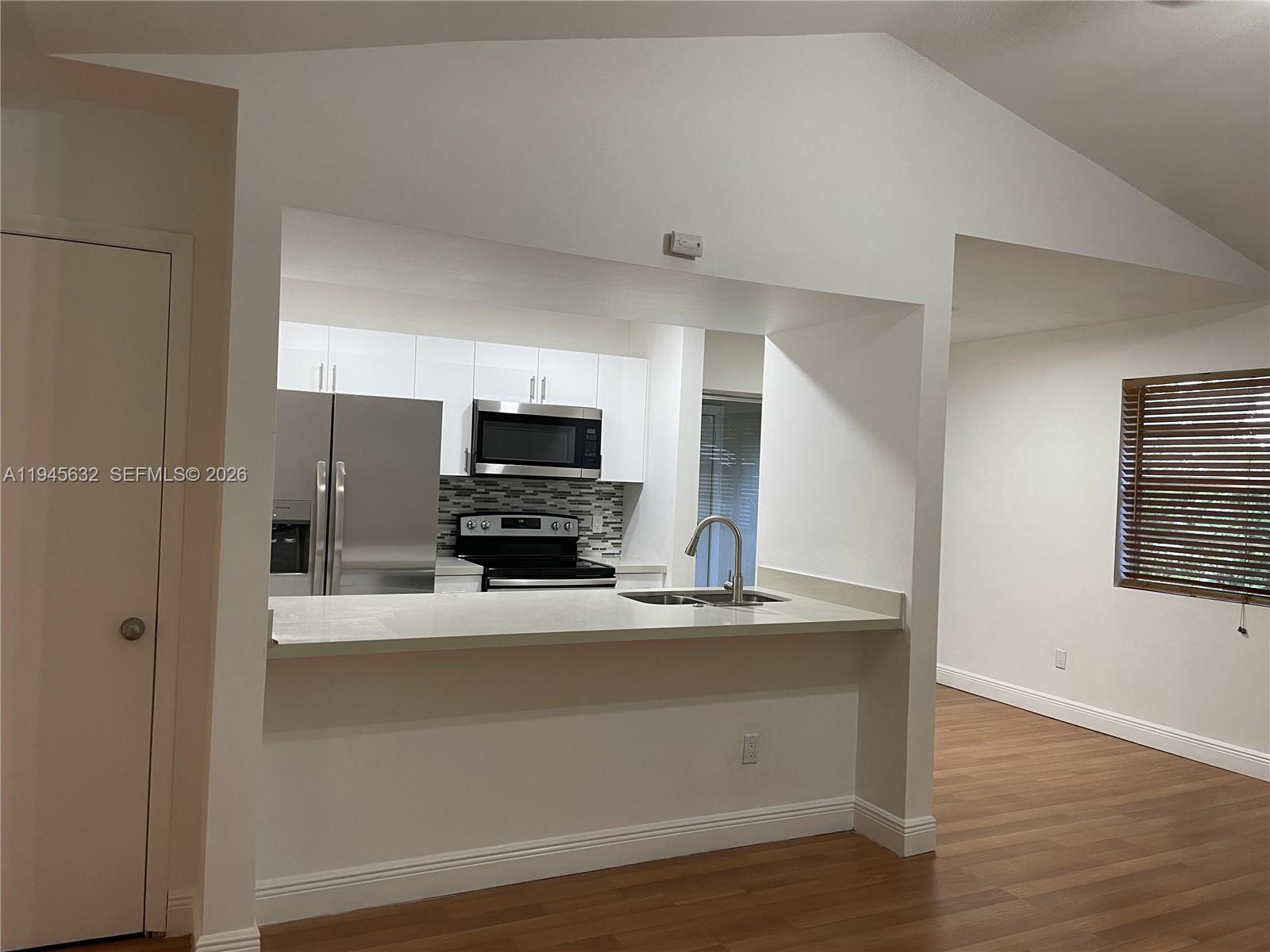 15325 Southwest 106th Terrace, Unit 618 Miami, FL 33196 - Photo 6 of 27 a kitchen with stainless steel appliances a sink a stove a microwave a refrigerator and cabinets